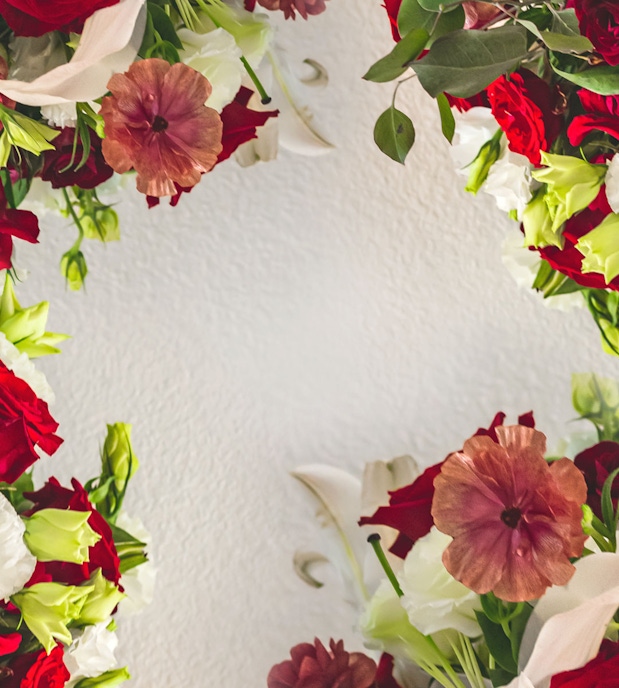 Vibrant floral arrangement featuring red roses, white blooms, and greenery in an artistic display.