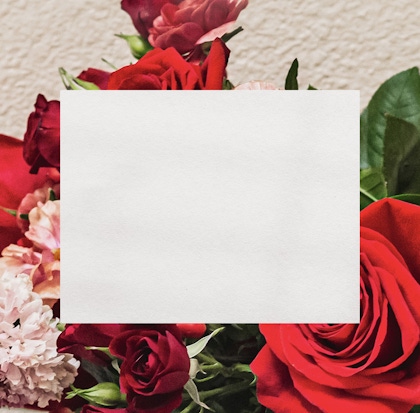 Vibrant mix of red and pink roses surrounded by lush greenery in a beautiful floral display.