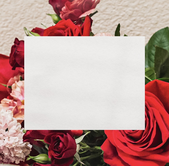 Vibrant mix of red and pink roses surrounded by lush greenery in a beautiful floral display.