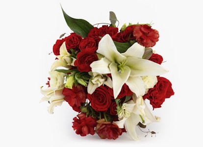 Vibrant floral arrangement featuring lush red roses and delicate white lilies with green foliage on a clean, white background.