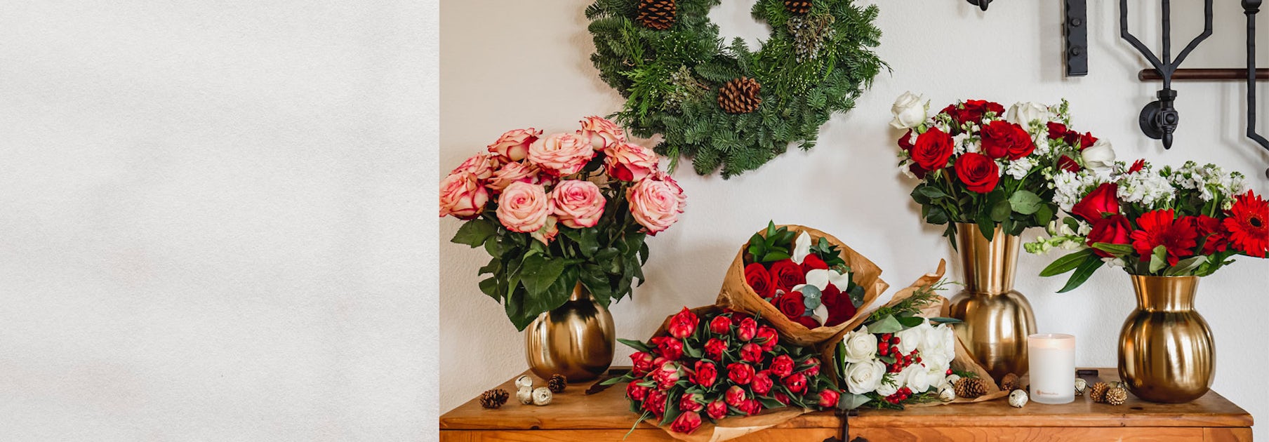 Elegant floral arrangement featuring red and pink roses in gold vases, complemented by greenery.