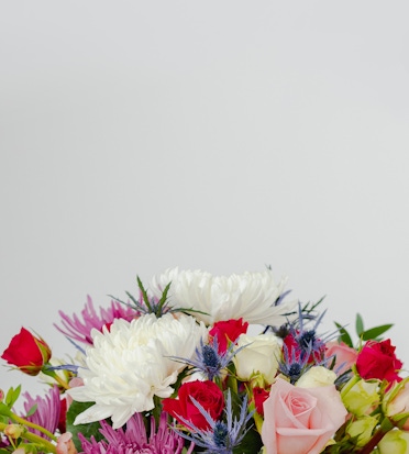 Vibrant floral arrangement featuring pink and white roses, green foliage, and colorful blooms.