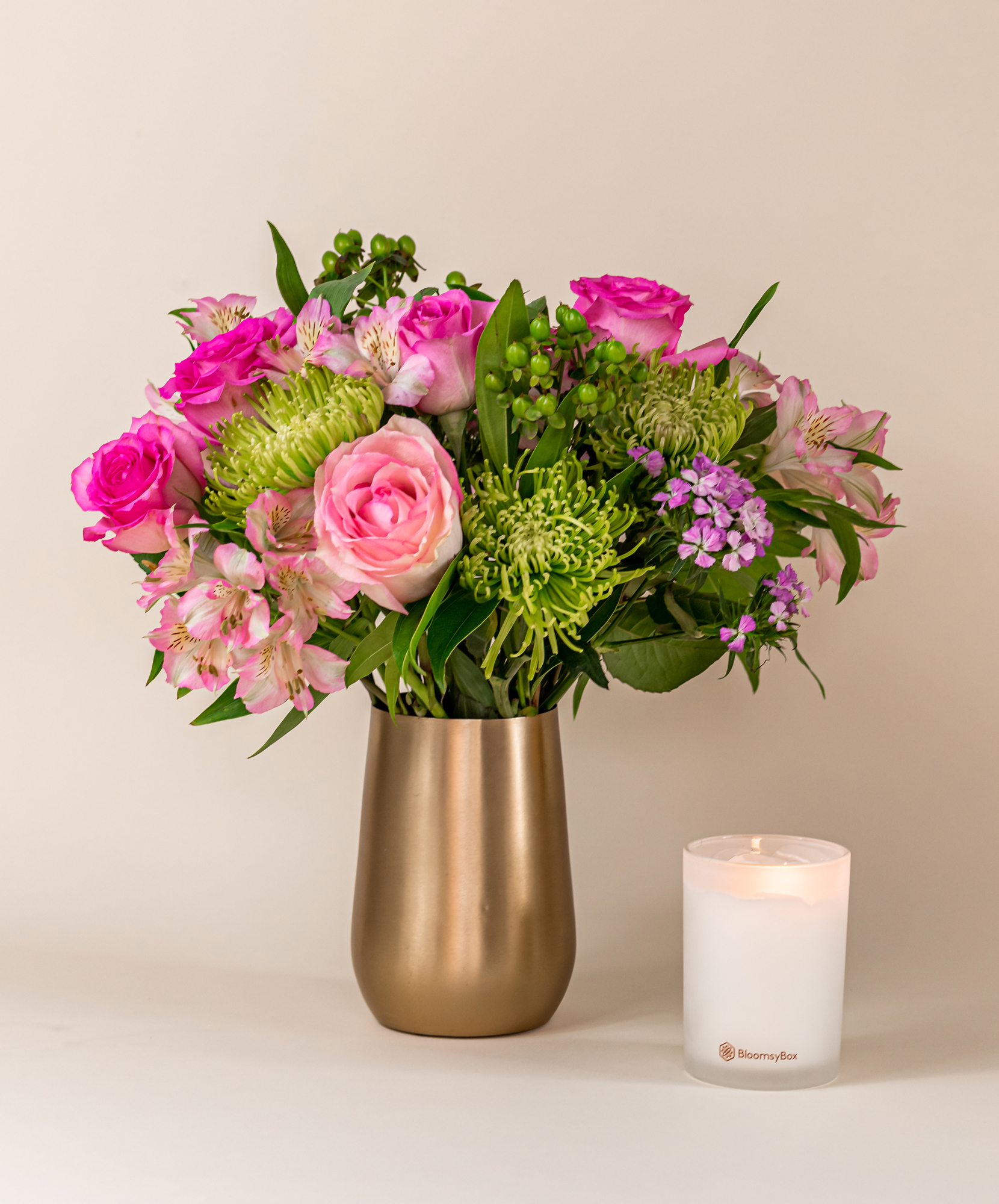 Beautiful floral arrangement featuring pink roses, green accents, and vibrant blooms in a chic vase.