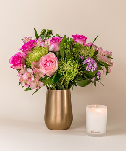 Beautiful floral arrangement featuring pink roses, green accents, and vibrant blooms in a chic vase.