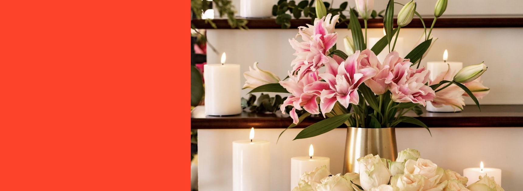 Elegant arrangement of pink lilies and white roses, complemented by glowing candles.