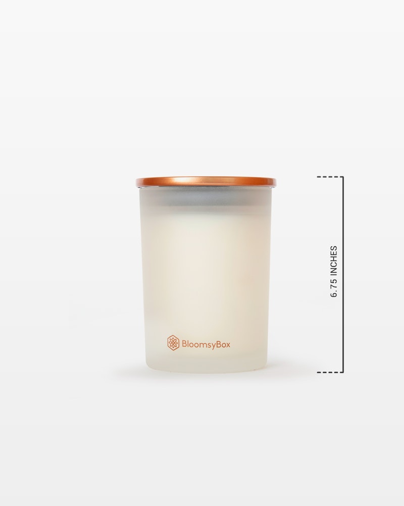 Elegant BloomsyBox candle with a warm white hue and copper lid, measured at 6.5 inches tall against a minimalistic white background.