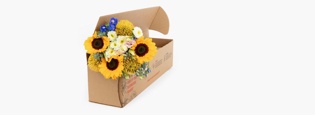 Bright sunflower bouquet with colorful blooms in a stylish gift box arrangement.
