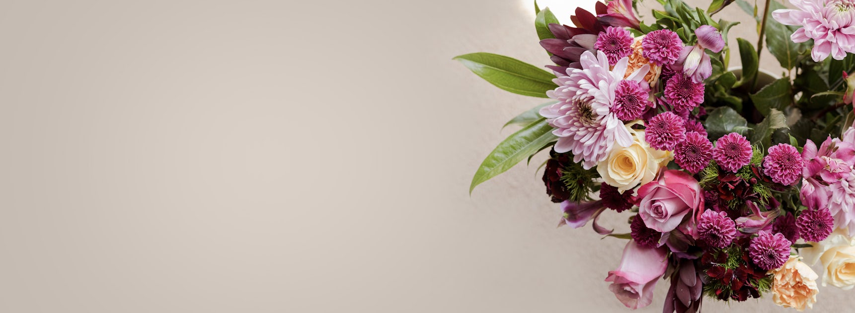 Elegant floral arrangement featuring pink roses, chrysanthemums, and lush greenery.