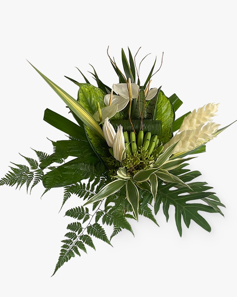 Elegant tropical floral arrangement featuring green bananas, white anthuriums, palm fronds, and lush ferns against a clean white background.