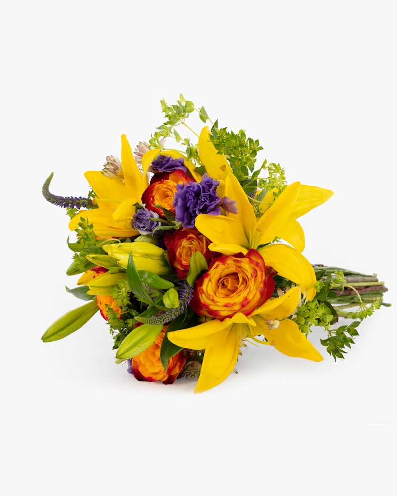 Vibrant bouquet of flowers featuring yellow lilies, orange ranunculus, purple accents, and lush greenery against a white background, ideal for special occasions.