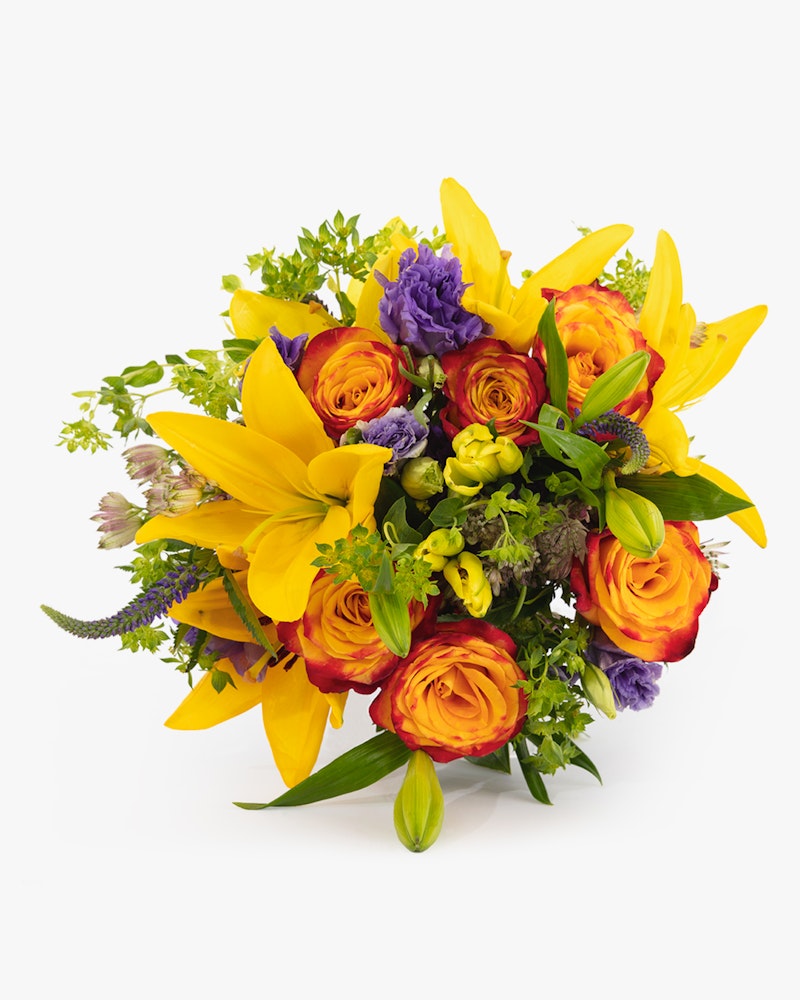 Vibrant bouquet featuring yellow lilies, orange roses, purple accents, and lush greenery, artistically arranged against a clean white background.
