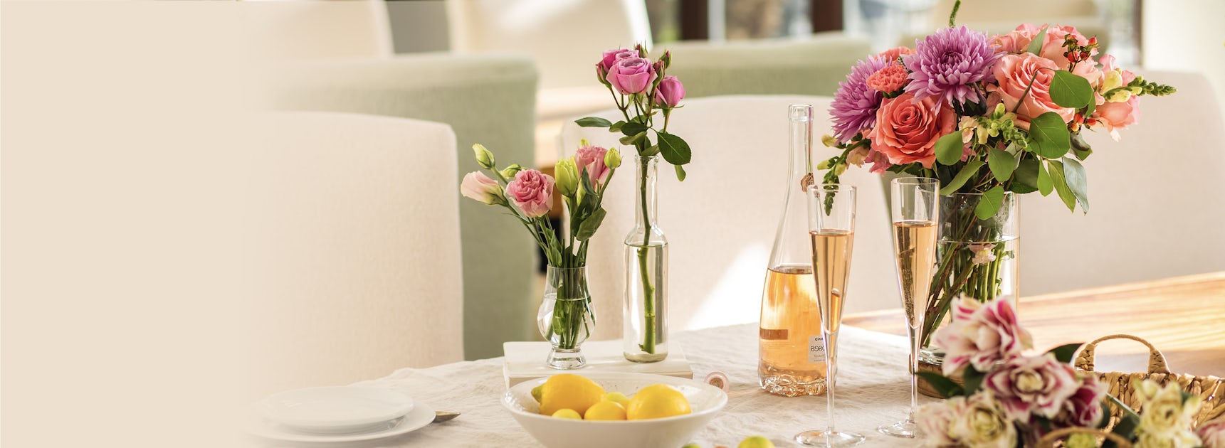 Elegant floral arrangements featuring roses and dahlias, enhancing a stylish dining table setup.