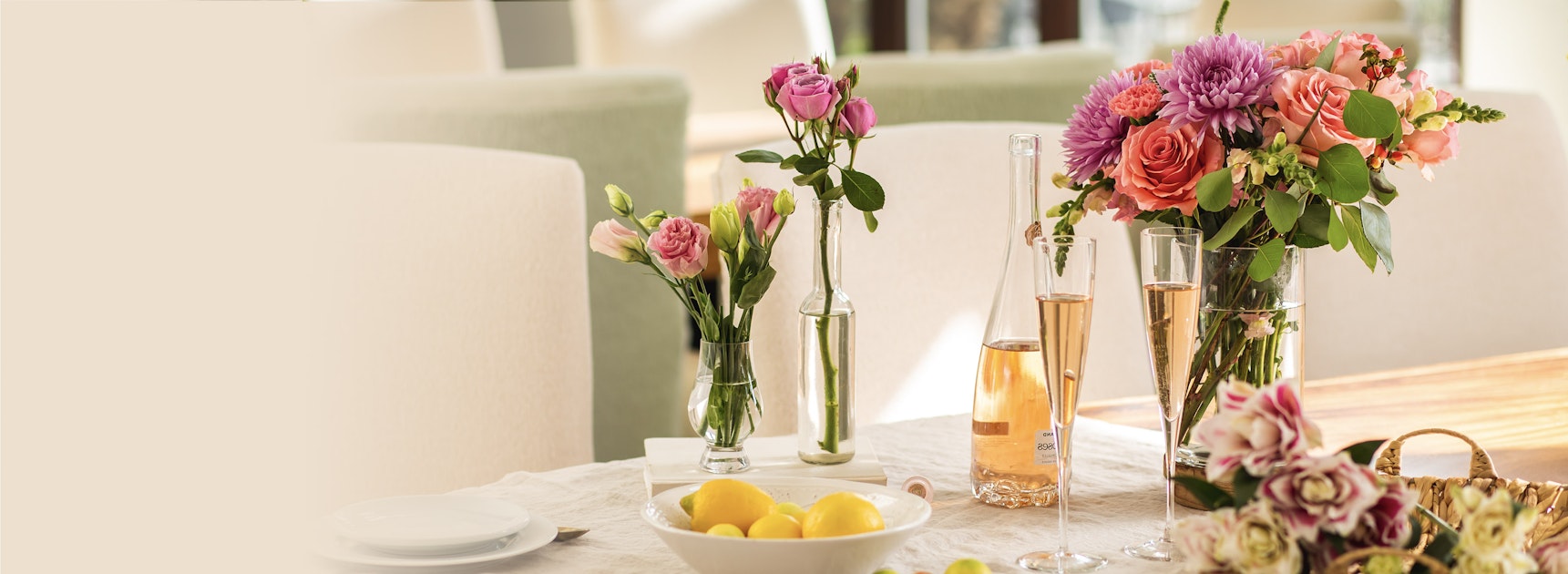 Elegant floral arrangements featuring roses and dahlias, enhancing a stylish dining table setup.