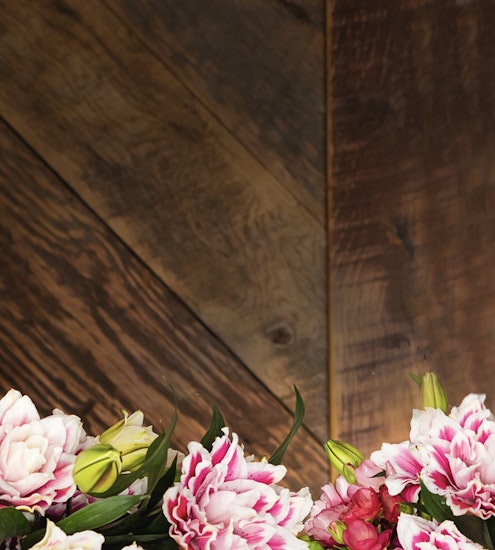 Vibrant floral arrangement featuring pink and white blooms against a rustic wood background.