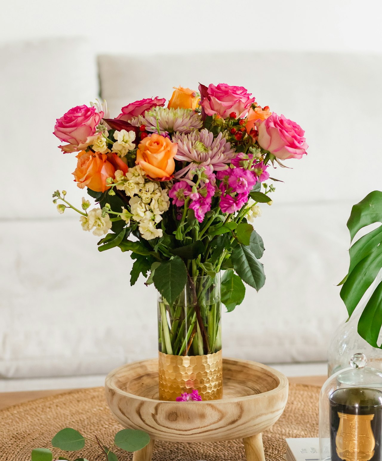 Vibrant floral arrangement featuring pink and orange roses with assorted blooms in a stylish vase.