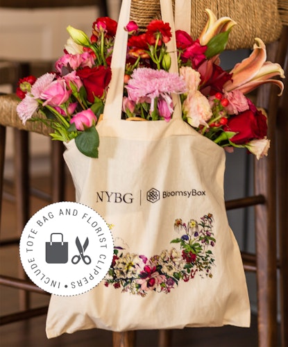 A stylish tote bag filled with vibrant flowers, perfect for gifting or decorations.