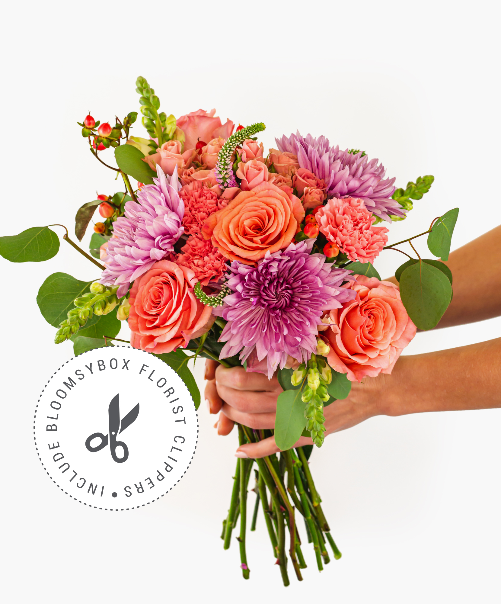 Vibrant floral bouquet featuring coral roses, purple chrysanthemums, and delicate greens.
