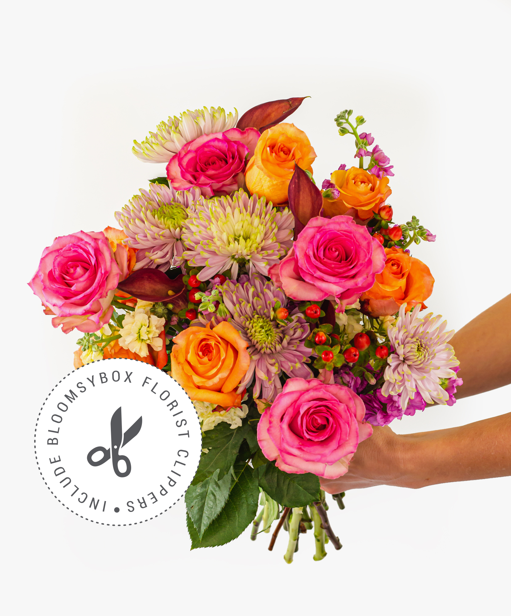 Vibrant bouquet featuring pink and orange roses, accented with colorful seasonal flowers.