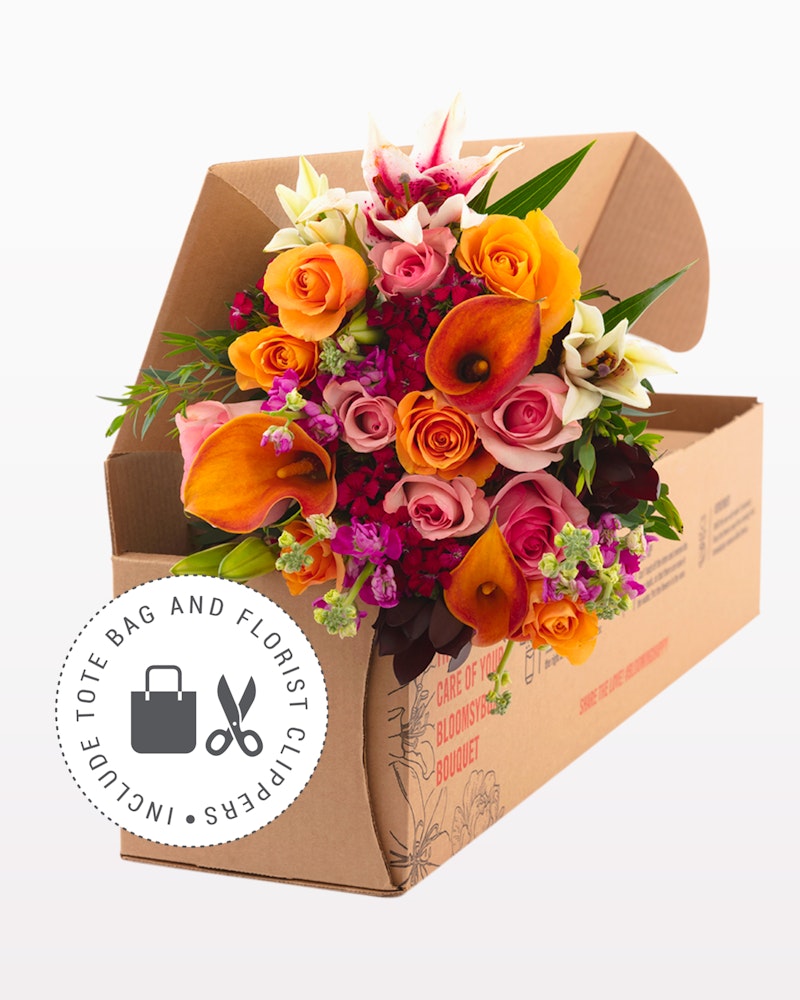 Vibrant bouquet of flowers with roses and lilies in a cardboard box ready for delivery, displaying bright oranges, pinks, and purples, symbolizing a thoughtful gift.
