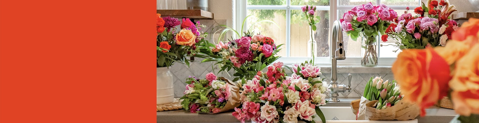 Vibrant flower arrangements featuring roses, tulips, and daisies in a sunny kitchen setting.