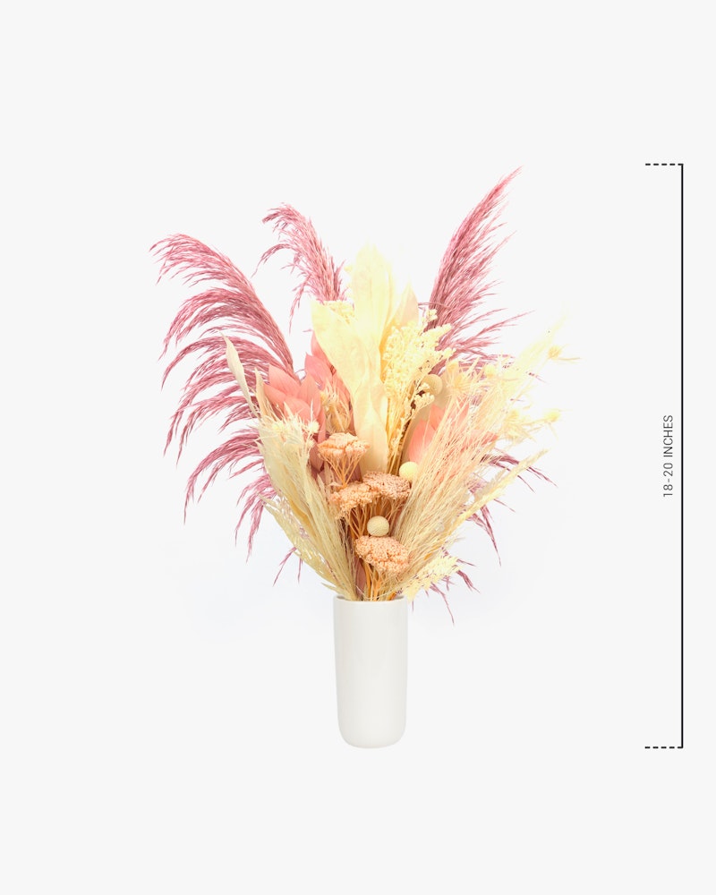 A stylish dried floral arrangement in pastel shades with feathers, housed in a sleek white vase, set against a clean, light background with a measuring scale.