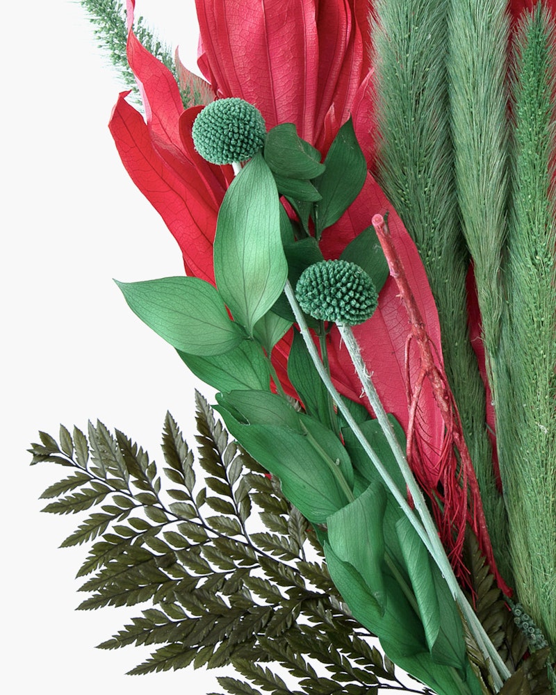 Vibrant artificial floral arrangement featuring red flowers, green leaves, and unique blue buds with textured foliage against a white background.