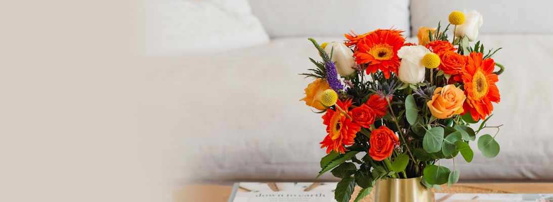 Vibrant bouquet featuring orange gerbera daisies and roses, perfect for brightening any space.