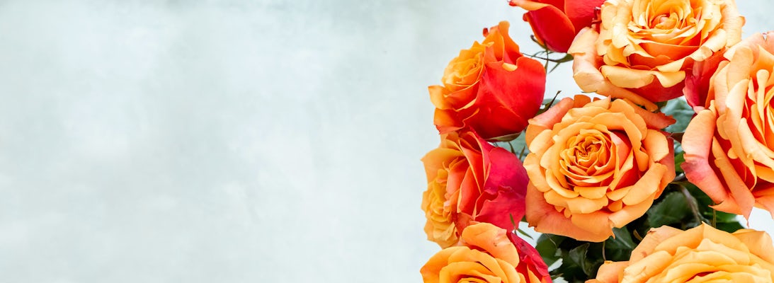 Vibrant orange and red roses in a lush arrangement, perfect for brightening any occasion.