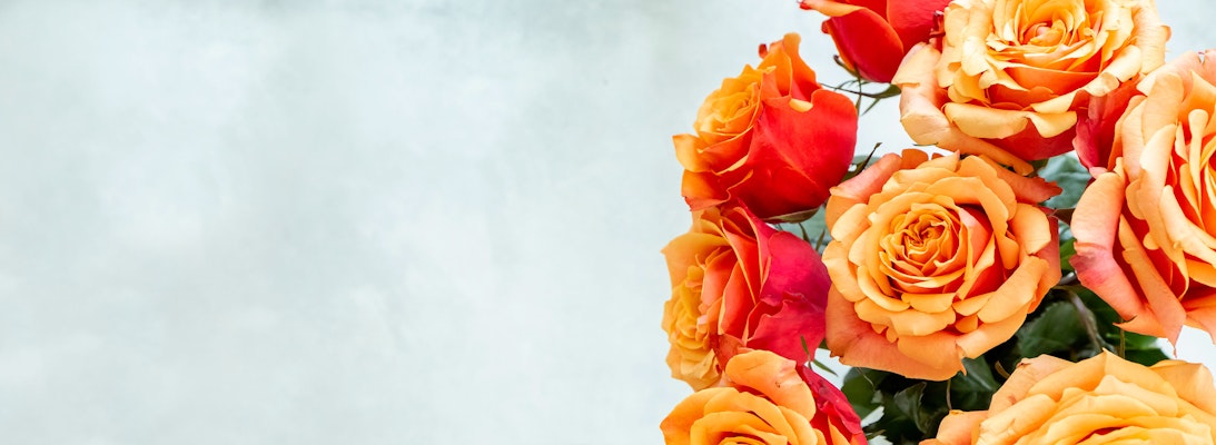 Vibrant orange and red roses in a lush arrangement, perfect for brightening any occasion.