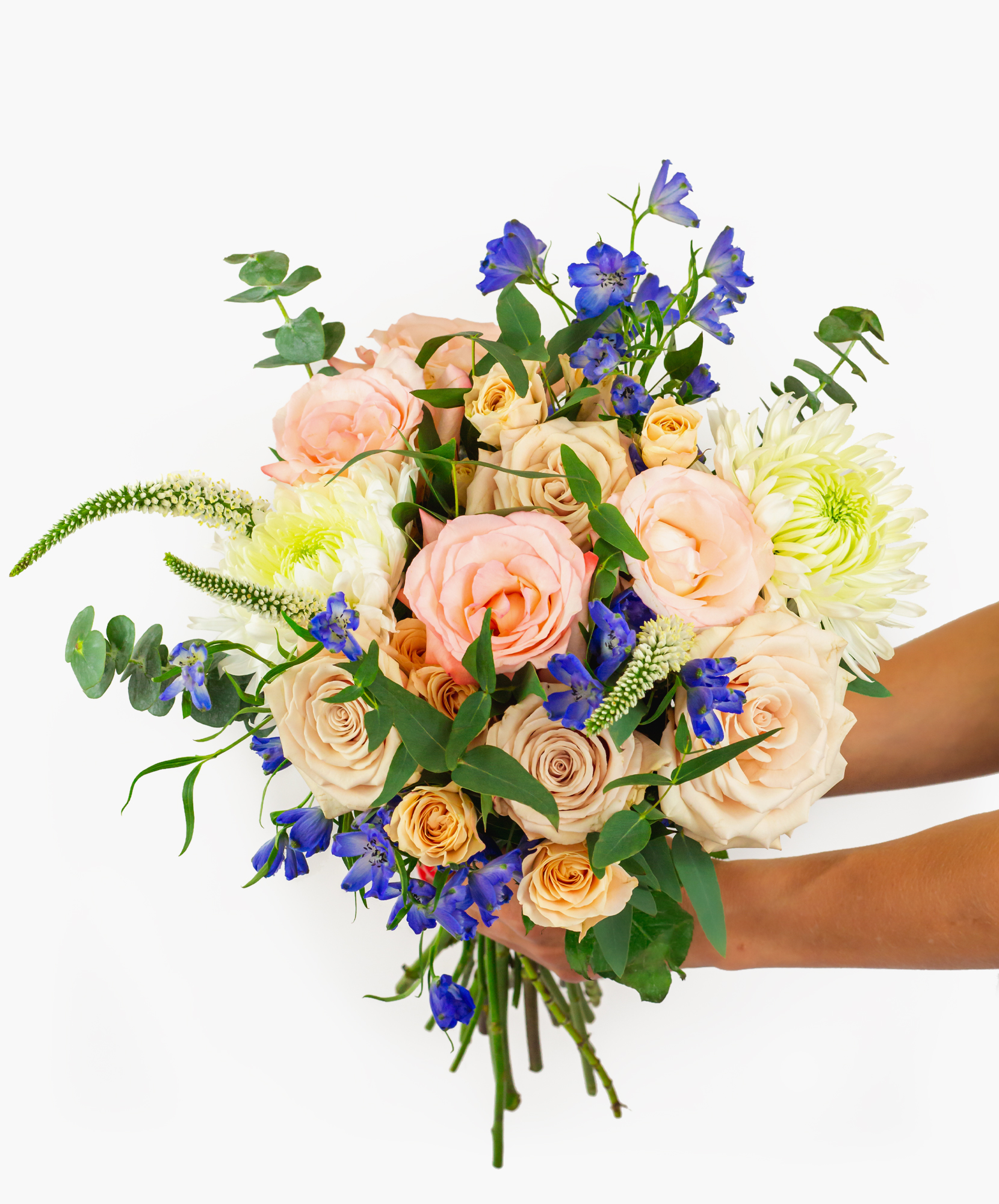 A vibrant flower bouquet featuring peach roses and blue delphiniums, perfect for celebrations.
