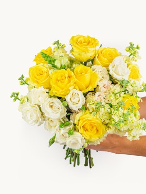 Bright yellow and white flower bouquet featuring roses and delicate blooms, beautifully arranged.