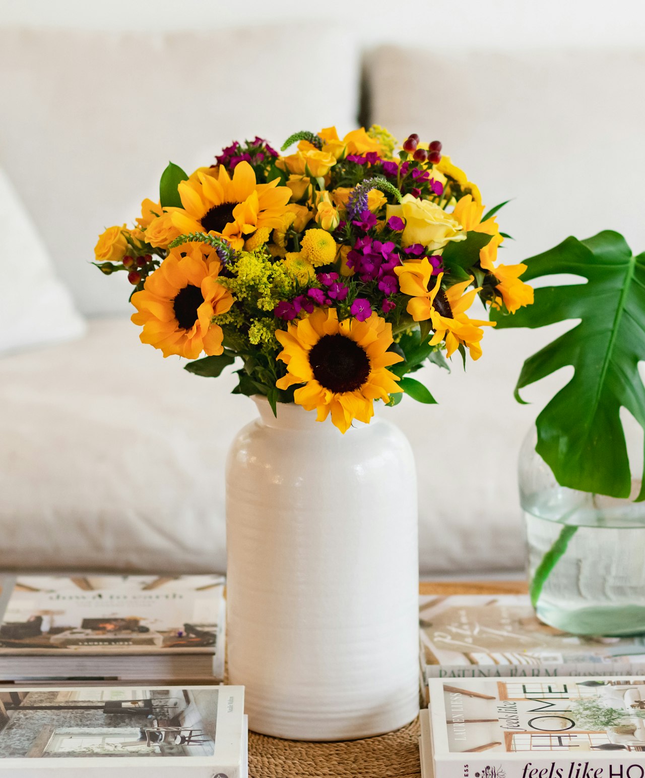 Vibrant bouquet of sunflowers and colorful blooms in a white vase, brightening up any space.