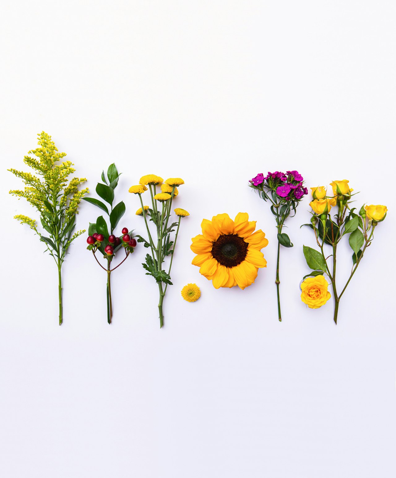 Vibrant arrangement of sunflowers, roses, and assorted greenery on a white background.