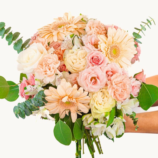 A lovely pastel bouquet featuring roses, gerbera daisies, and lush greenery.