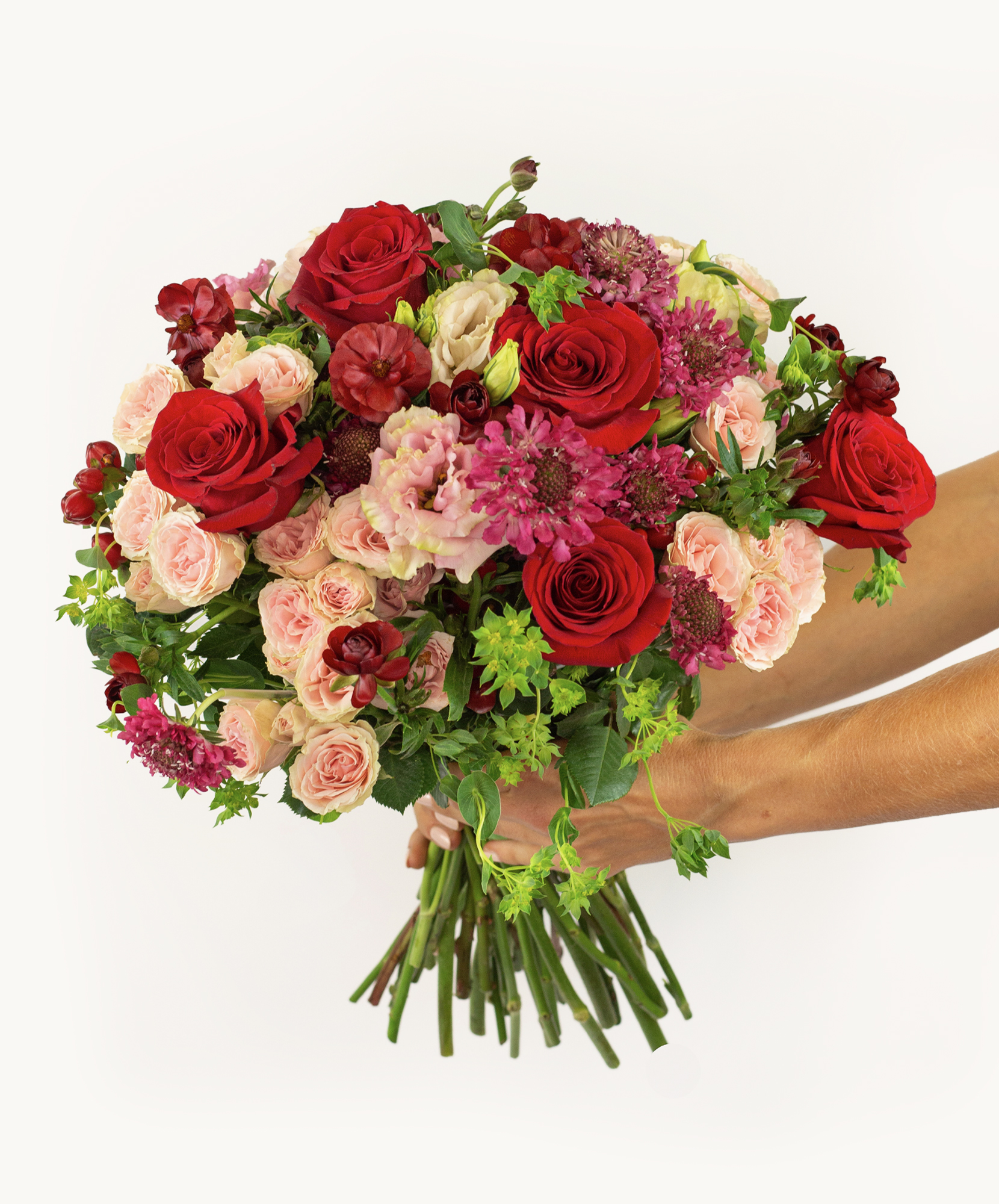 Vibrant bouquet featuring red roses, pink blooms, and lush greenery, ideal for celebrations.