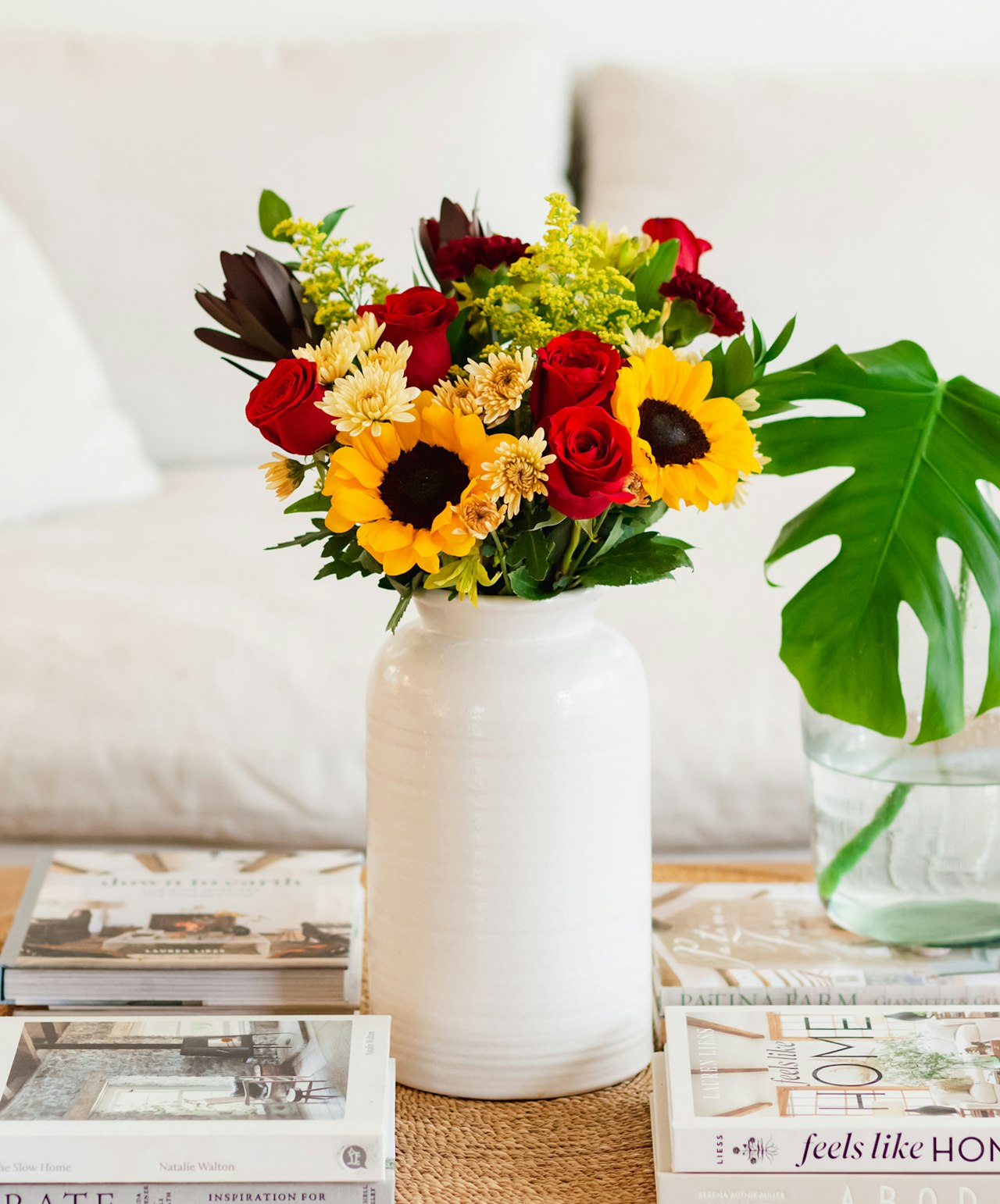 Vibrant floral arrangement featuring sunflowers, red roses, and yellow blooms in a chic vase.