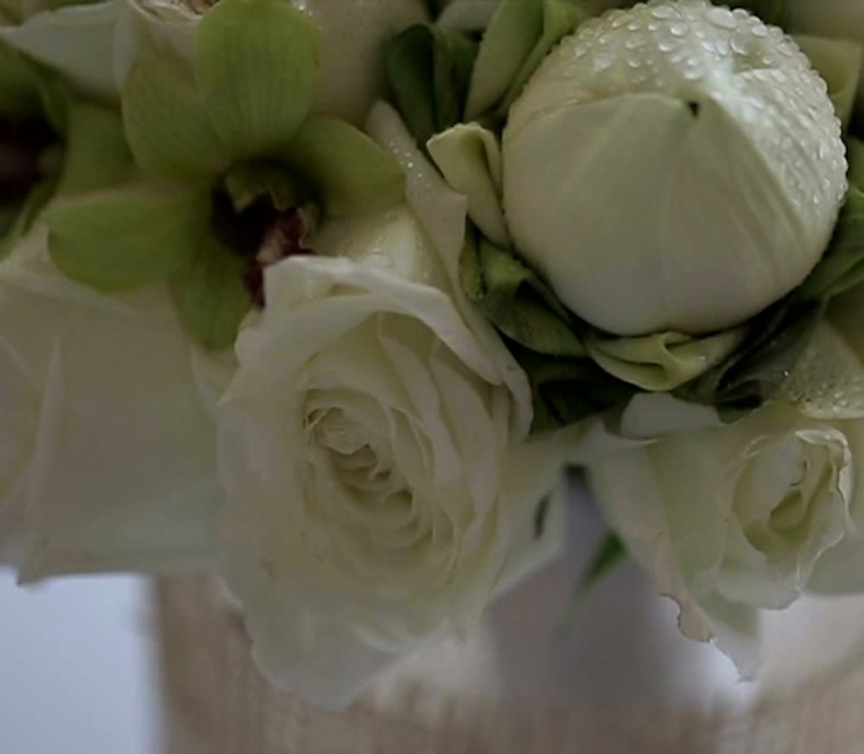 Elegant white roses and lush green accents in a delicate floral arrangement.