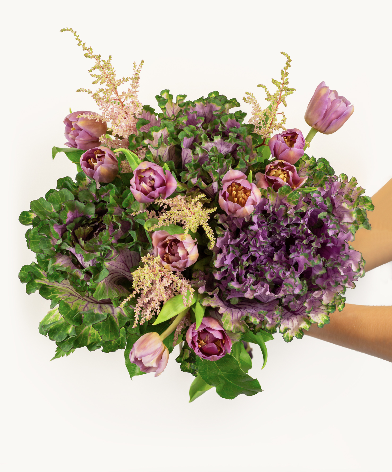 Lush bouquet featuring purple tulips and textured greens, perfect for any special occasion.