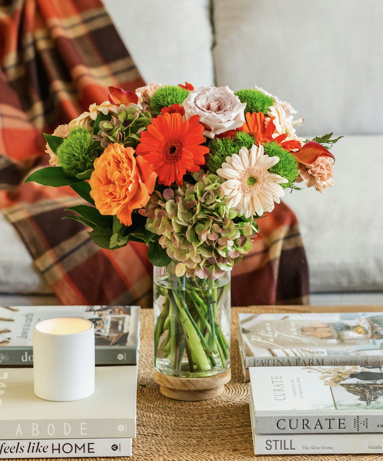 Vibrant floral arrangement featuring gerbera daisies, roses, and greenery in a chic vase.