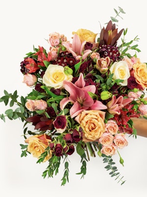 Vibrant floral bouquet featuring roses, lilies, and greenery, perfect for celebrations.