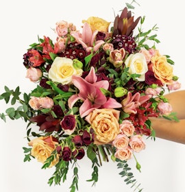 Vibrant floral bouquet featuring roses, lilies, and greenery, perfect for celebrations.