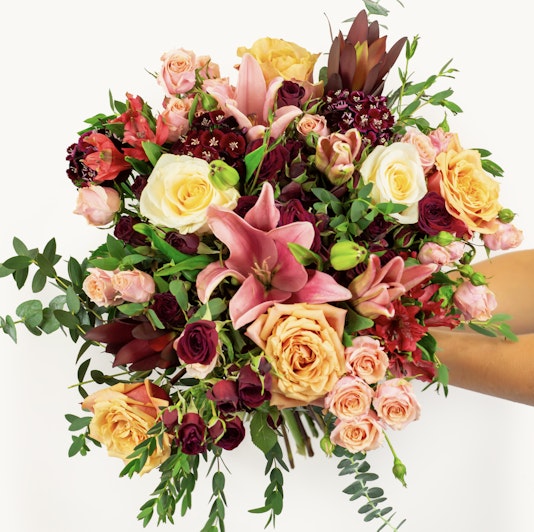 Vibrant floral bouquet featuring roses, lilies, and greenery, perfect for celebrations.