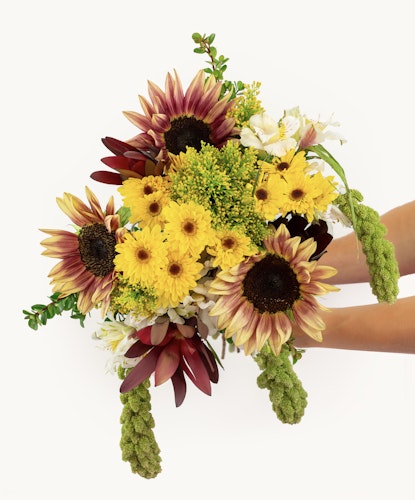 Bright and cheerful bouquet featuring sunflowers, daisies, and lush greenery for vibrant decor.