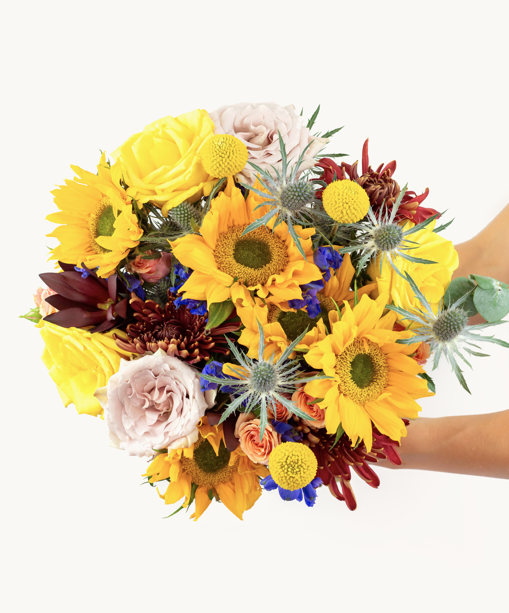 Vibrant bouquet featuring sunflowers, roses, and colorful wildflowers, perfect for celebrations.