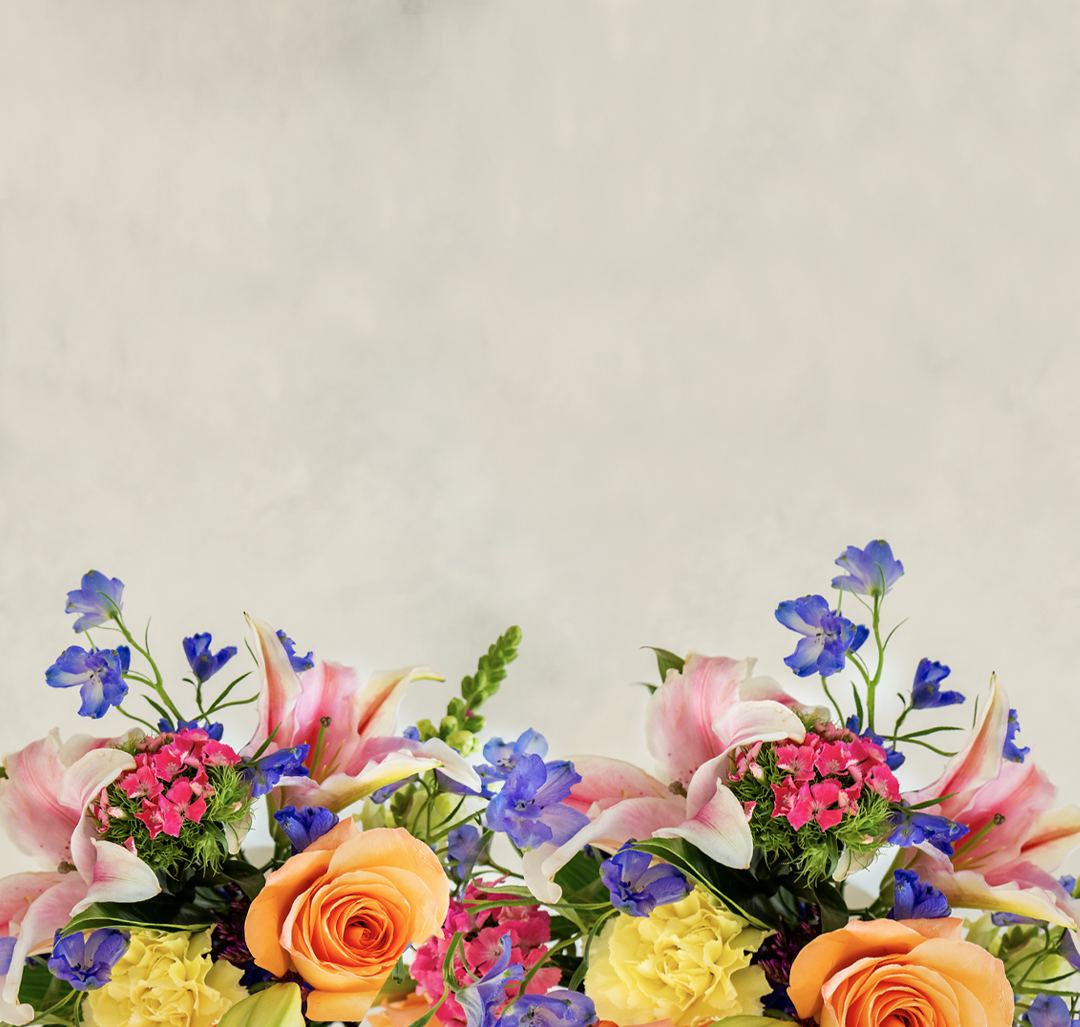 Vibrant floral arrangement featuring lilies, roses, and colorful blooms in a lush display.