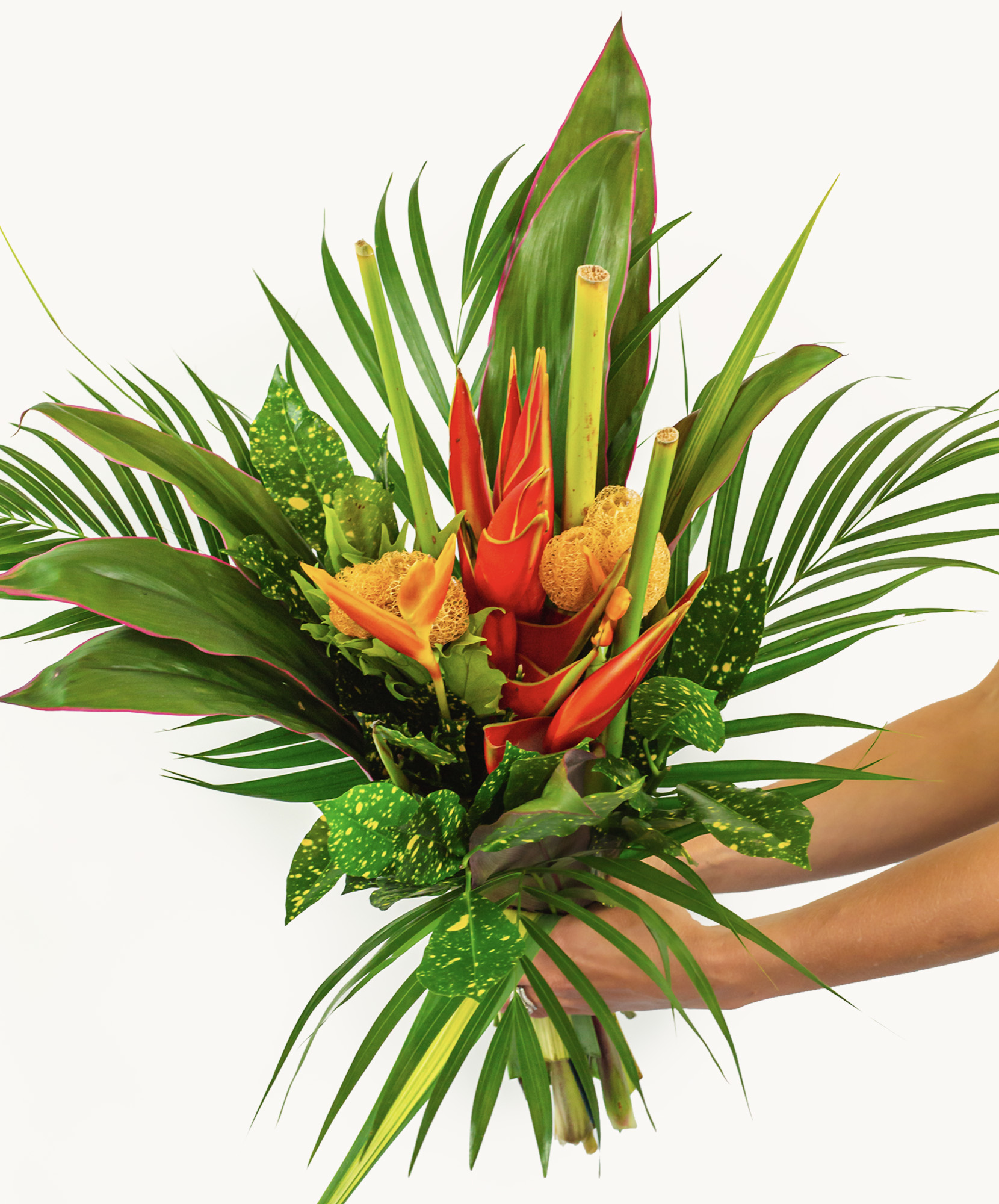 Vibrant tropical flower bouquet featuring red heliconias and lush green leaves.
