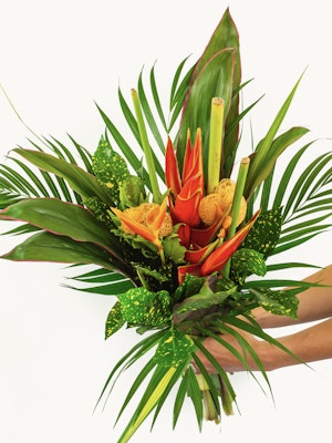Vibrant tropical flower bouquet featuring red heliconias and lush green leaves.