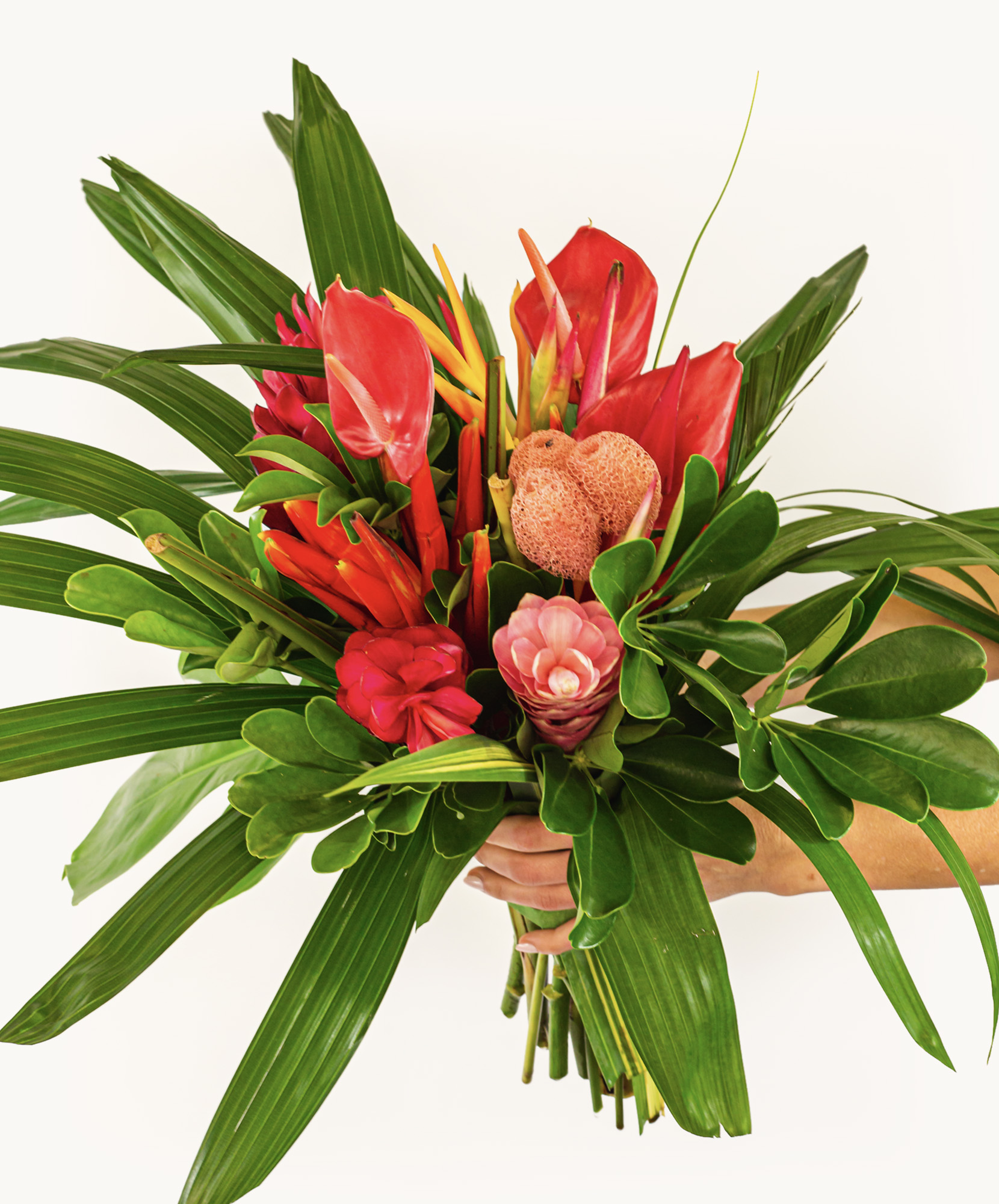 Vibrant tropical flower bouquet featuring red blooms and lush green foliage.