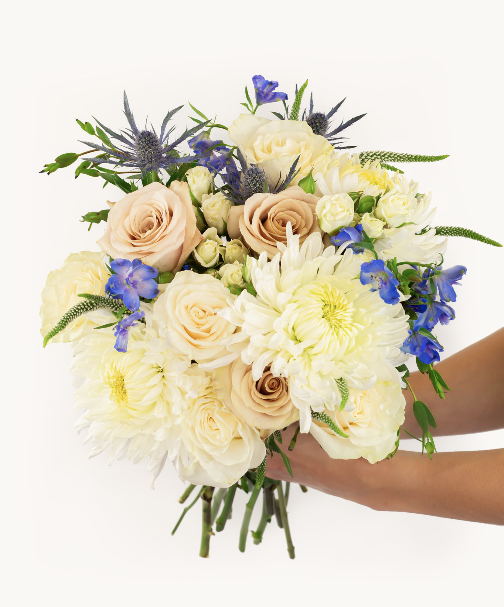 Beautiful floral bouquet featuring cream roses, white chrysanthemums, and blue delphiniums.