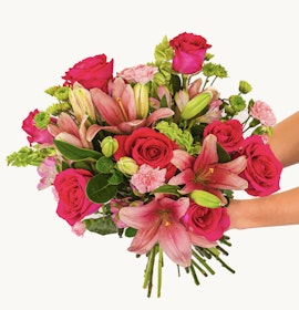 Vibrant bouquet featuring pink roses, lilies, and assorted greens in a stunning floral arrangement.